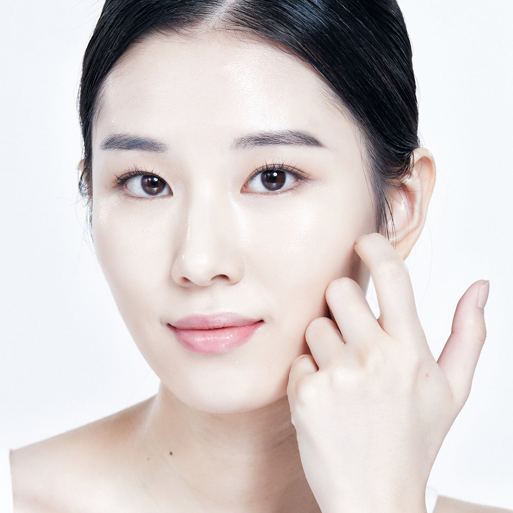 Model wearing a Mixsoon sheet mask and pressing it against her cheek