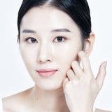 Model wearing a Mixsoon sheet mask and pressing it against her cheek