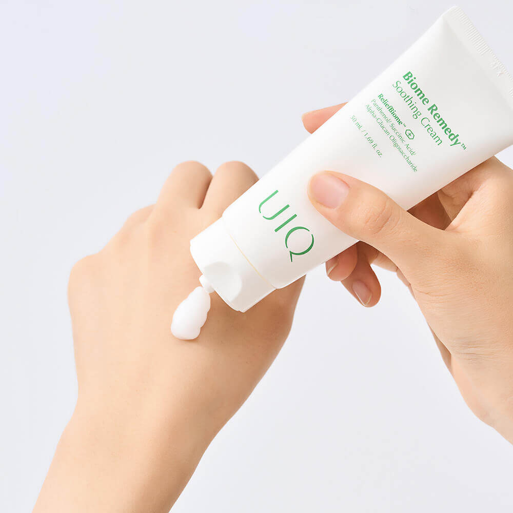 UIQ Biome Remedy Soothing Cream being dispensed onto the back of a hand