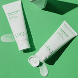 Two UIQ Biome Remedy Soothing Cream tubes with cream swatches on a green background